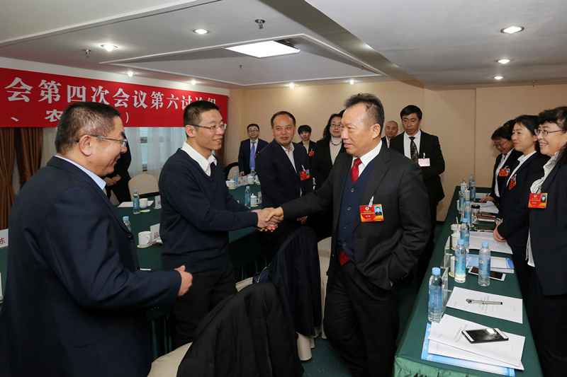 市政协主席杨枫与参加分组讨论的政协委员亲切握手