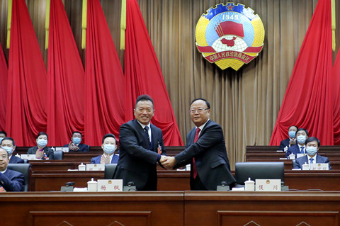 新当选的市政协主席侯川与市政协原主席杨枫亲切握手